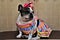 A french bulldog hillbilly in a dress and colorful bow on her seated head