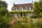 french country house exterior with flowering garden and butterfly