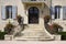 french country house exterior with majestic staircase leading to front door