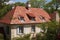 french country house roof with bold red tile roof and dormer windows