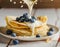 French crepes covered with white chocolate, decorated with blueberries, sweet breakfast on a wooden table