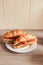 French croissant with cucumber salmon on white plate, Vertical photo orientation