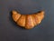 French croissant on grey slate background. Idea minimal concept