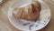 French croissants on a plate, close up. Stock footage. Delicious freshly baked crispy croissant lying on the plate on