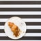 French croissants on a plate on striped background, top view. Delicious breakfast. Have a nice day