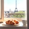 French croissants and a white cup of coffee by an open window overlooking the Paris Tower. Morning breakfast. Close-up