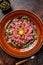 French cuisine Beef tartare with raw egg yolk. Dark background. Top view