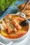 French fish soup Bouillabaisse with seafood, salmon fillet, shrimp, rich taste, delicious dinner in a white beautiful plate.