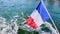 French flag close-up on the boat over river water