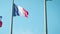 French flag fabric waving in front of blue sky. Tricolor flag of France.