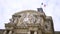 French flag waving in the wind on a historic building, architecture concept. Action. Bottom view of a beautiful old