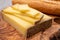 French food -  piece of cheese comte made from cow milk in region Franche-Comte in France and fresh baked baguette bread