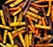 French fries,  baked fries from different types and colors of potatoes sprinkled with herbs and spices on a black background