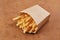 French fries in a brown kraft paper bag. Fast food. Food paper packaging from environmentally friendly materials. Eco