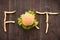 French fries with burger forming word fat on wooden background