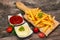 French fries on chopping board with tomato sauce and mayonnaise