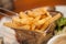 French fries in little metallic basket in a plate at