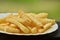 French fries on rustic rosemary and spices in a white plate
