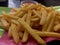 French fries with tomato sauce on a green melamine plate. top view