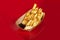 French fries with two sauces in a paper plate. Takeout food. Colored background