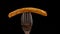 French fry on a fork rotate on black background