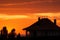 french house hipped roof silhouette against an orange sunset