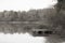 French lake with a wooden pier surrounded by woods in Autumn