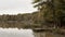 French lake with a wooden pier surrounded by woods in Autumn