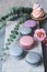 French macaroons and cupcakes with flowers on marble background.