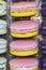 French macaroons dessert range lilac yellow with plastic case. Sweet macaroons cookies for tea. Two-colored macaroon with cream in