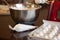 French meringue cookies on a rusty pan, pastry pouch, red mixer and chrome mixing bowl on brown wooden table