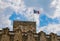 French national flag waving over Grimaldi castle in Antibes, French Riviera, France