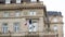 French National tricolor flag waving on a Haussmannian apartment