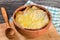 French onion gratin soup in a clay pot, authentic recipe, wooden spoon on a cutting board on an old rustic table, close-up