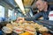 French patisserie chef places desserts in display counter