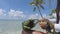 French polynesian culture - woman weaving a purse out of palm leaves