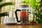 French press brewed cacao nibs and white cup of cocoa on wooden table