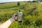 French press in hand on the backdrop of summer sunny suburban landscape with blue sky and greenery