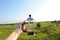 French press in hand on the backdrop of summer sunny suburban landscape with blue sky and greenery