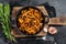 French roasted chanterelle mushrooms with onions and thyme in a pan. Black background. Top view