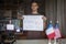 French student holding a poster with anti-racism message and recording a video to support black American citizens