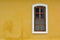 A French style white Window on a yellow wall in Pondicherry, India