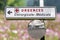 French Surgery Emergency Sign for a Hospital with car exit mirror, against a flower landscape