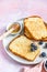 French toast drizzled with honey and coconut flakes and blueberry on craft ceramic plate, pink background. Breakfast concept