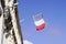 French tricolor flag waving in front facade of town hall in city of france