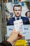 French voter registration card held in front of Emmanuel Macron