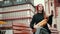 French woman is sitting on bench in black jacket, holding loaves of bread