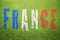 French word in flag colors on green sunny soccer grass