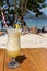 Fresh alcohol cocktail on the beach. Cold pina colada on seascape background. Cool pineapple cocktail with stick. Exotic resort.