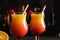 Fresh alcoholic Tequila Sunrise cocktails against blurred lights